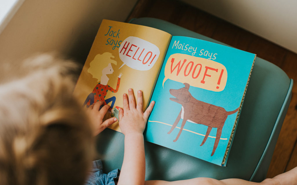 Little girl reading a simple picture book.